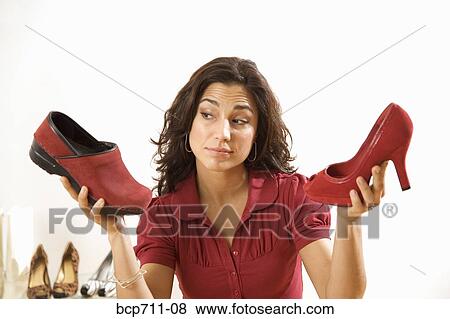 Woman comparing shoes at boutique View Large Photo Image Stock Photo - Woman comparing shoes at boutique. Fotosearch