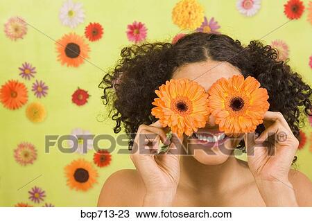 Stock Image - Woman holding flowers over eyes. Fotosearch