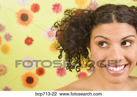 Woman looking sideways in front of flower background View Large Photo Image Stock Image - Woman looking sideways in front of flower background. Fotosearch