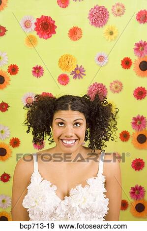 Woman looking up in front of flower background View Large Photo Image Stock Photo - Woman looking up in front of flower background. Fotosearch