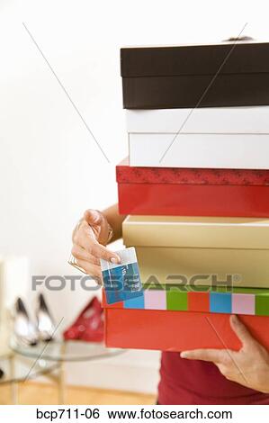 Woman paying for stack of items at boutique View Large Photo Image Stock Photograph - Woman paying for stack of items at boutique. Fotosearch