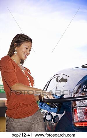 Woman pumping gas at service station View Large Photo Image Stock Image - Woman pumping gas at service station. Fotosearch