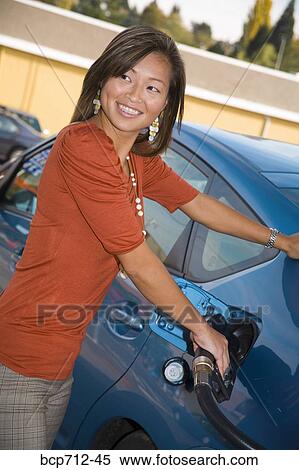 Woman pumping gas at service station View Large Photo Image Stock Photography - Woman pumping gas at service station. Fotosearch