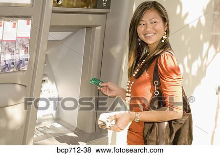 Woman smiling and using ATM View Large Photo Image Stock Photo - Woman smiling and using ATM. Fotosearch
