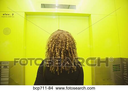 Woman standing in elevator View Large Photo Image Picture - Woman standing in elevator. Fotosearch