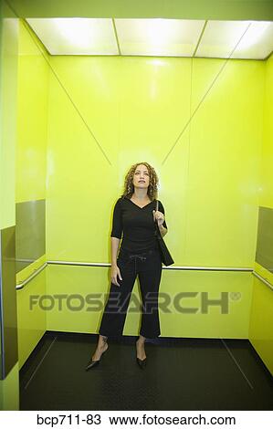 Woman standing in elevator View Large Photo Image Stock Image - Woman standing in elevator. Fotosearch