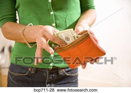 Stock Photo - Woman taking money out of wallet. Fotosearch