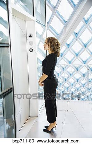 Stock Image - Woman waiting for elevator. Fotosearch