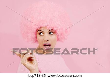 Stock Photography - Woman wearing pink wig and pointing. Fotosearch