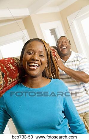 Stock Image - African couple carrying rug. Fotosearch