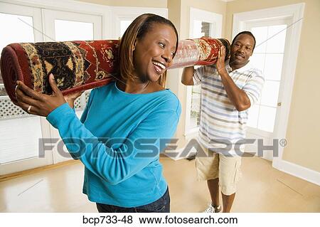 Stock Photo - African couple carrying rug. Fotosearch