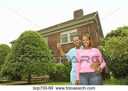 Stock Photo - African couple in front of new house. Fotosearch
