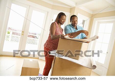 Stock Photo - African couple looking at blueprints. Fotosearch