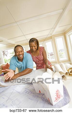 Stock Photo - African couple looking at blueprints. Fotosearch