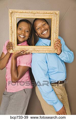 African couple looking through picture frame View Large Photo Image Stock Photo - African couple looking through picture frame. Fotosearch