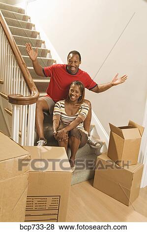 Stock Photo - African couple next to moving boxes. Fotosearch