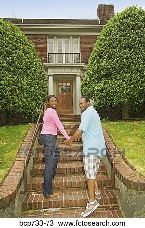 Stock Image - African couple walking towards house. Fotosearch