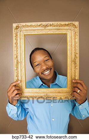 African man looking through picture frame View Large Photo Image Stock Image - African man looking through picture frame. Fotosearch