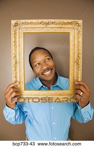 African man looking through picture frame View Large Photo Image Stock Image - African man looking through picture frame. Fotosearch