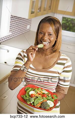 African woman holding plate of vegetables View Large Photo Image Stock Image - African woman holding plate of vegetables. Fotosearch
