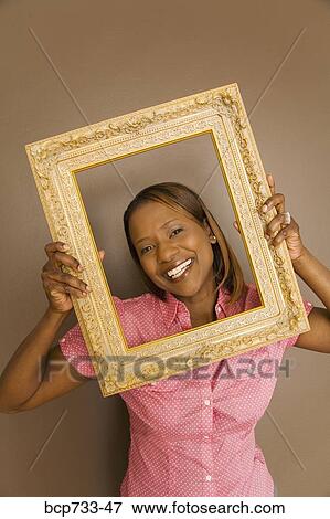 African woman looking through picture frame View Large Photo Image Stock Photo - African woman looking through picture frame. Fotosearch