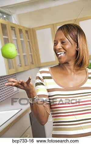 African woman throwing apple View Large Photo Image Stock Photograph - African woman throwing apple. Fotosearch