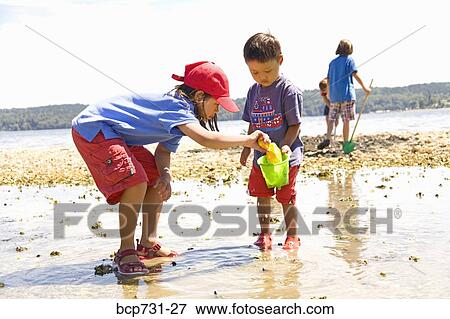 Asian sister and brother playing at beach View Large Photo Image Stock Photo - Asian sister and brother playing at beach. Fotosearch