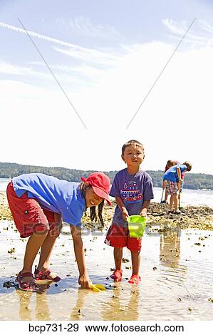 Asian sister and brother playing at beach View Large Photo Image Stock Photo - Asian sister and brother playing at beach. Fotosearch