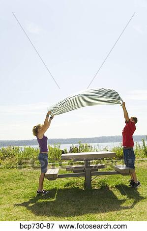Boy and girl placing table cloth on picnic table View Large Photo Image Stock Photo - Boy and girl placing table cloth on picnic table. Fotosearch