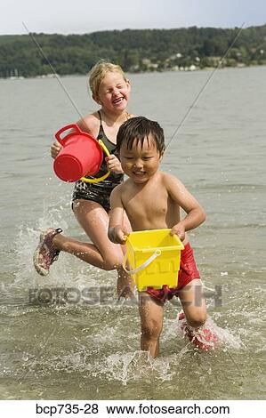 Stock Photo - Boy and girl playing in water. Fotosearch