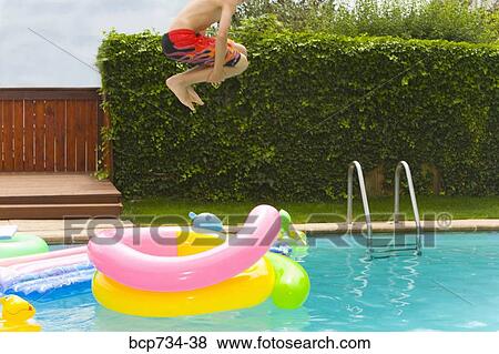 Boy jumping into swimming pool View Large Photo Image Stock Photo - Boy jumping into swimming pool. Fotosearch