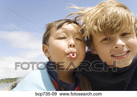 Stock Photo - Boy making face next to friend. Fotosearch
