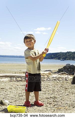 Boy playing with baseball bat at beach View Large Photo Image Picture - Boy playing with baseball bat at beach. Fotosearch
