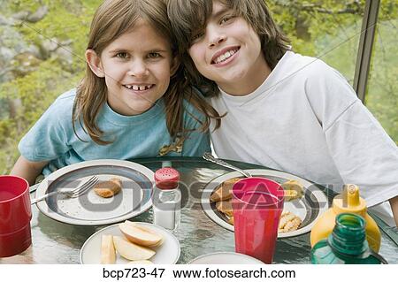 Brother and sister eating outside View Large Photo Image Stock Photo - Brother and sister eating outside. Fotosearch