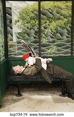 Businessman holding baby at bus stop View Large Photo Image Picture - Businessman holding baby at bus stop. Fotosearch