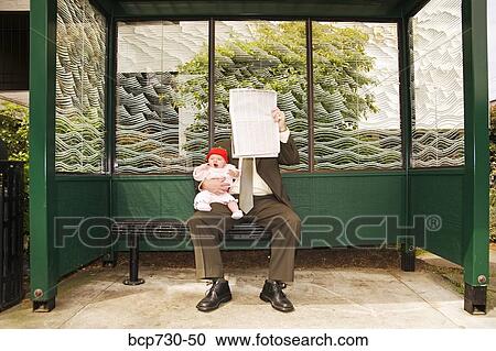 Businessman holding baby at bus stop View Large Photo Image Stock Image - Businessman holding baby at bus stop. Fotosearch