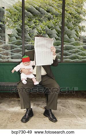 Businessman holding baby at bus stop View Large Photo Image Stock Photo - Businessman holding baby at bus stop. Fotosearch