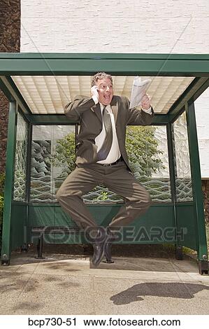Businessman jumping at bus stop View Large Photo Image Stock Image - Businessman jumping at bus stop. Fotosearch