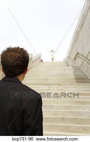 Businessman looking at businesswoman at top of steps View Large Photo Image Stock Image - Businessman looking at businesswoman at top of steps. Fotosearch