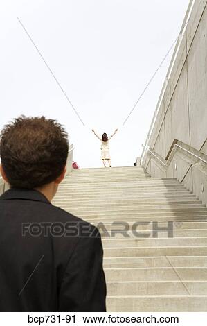 Businessman looking at businesswoman at top of steps View Large Photo Image Stock Image - Businessman looking at businesswoman at top of steps. Fotosearch