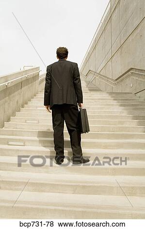 Businessman looking up steps View Large Photo Image Stock Photo - Businessman looking up steps. Fotosearch