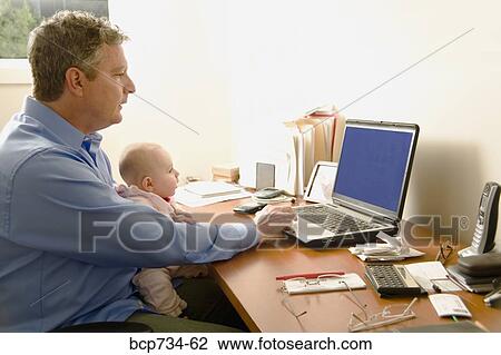 Businessman working with baby on lap View Large Photo Image Stock Image - Businessman working with baby on lap. Fotosearch