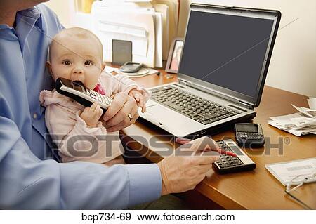 Businessman working with baby on lap View Large Photo Image Stock Photo - Businessman working with baby on lap. Fotosearch