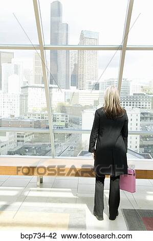 Stock Image - Businesswoman looking out window. Fotosearch