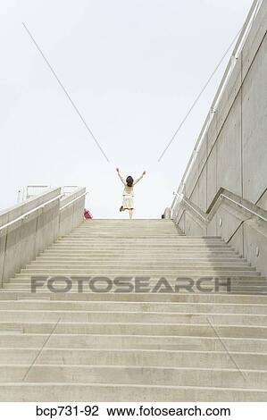 Businesswoman with arms raised at top of steps View Large Photo Image Stock Image - Businesswoman with arms raised at top of steps. Fotosearch