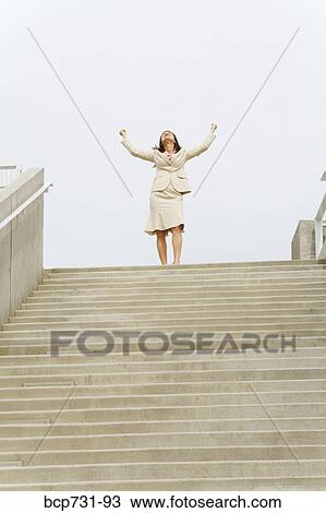 Businesswoman with arms raised at top of steps View Large Photo Image Stock Image - Businesswoman with arms raised at top of steps. Fotosearch
