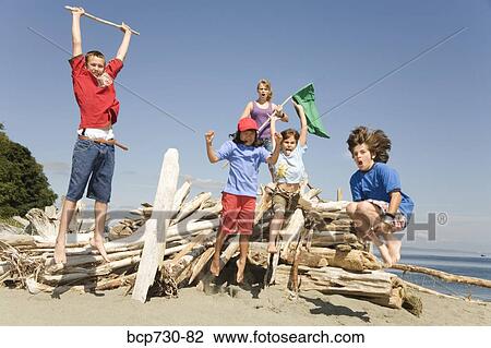Children jumping next to beach fort View Large Photo Image Stock Image - Children jumping next to beach fort. Fotosearch