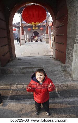 Stock Photograph - Chinese boy standing in archway, Tianjin, China. Fotosearch