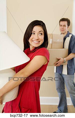 Couple carrying moving boxes and lamp View Large Photo Image Stock Photo - Couple carrying moving boxes and lamp. Fotosearch
