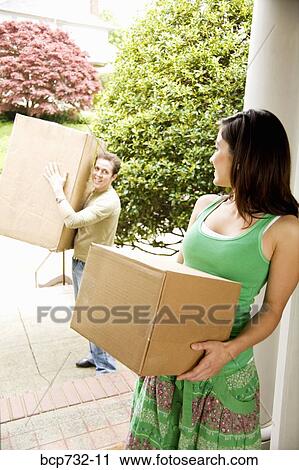 Couple carrying moving boxes View Large Photo Image Stock Image - Couple carrying moving boxes. Fotosearch